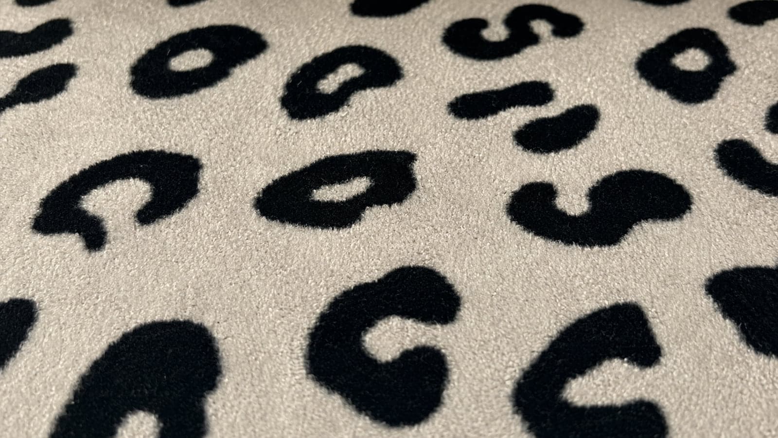 Tecido flocado com padronagem leopardo em preto sobre base creme