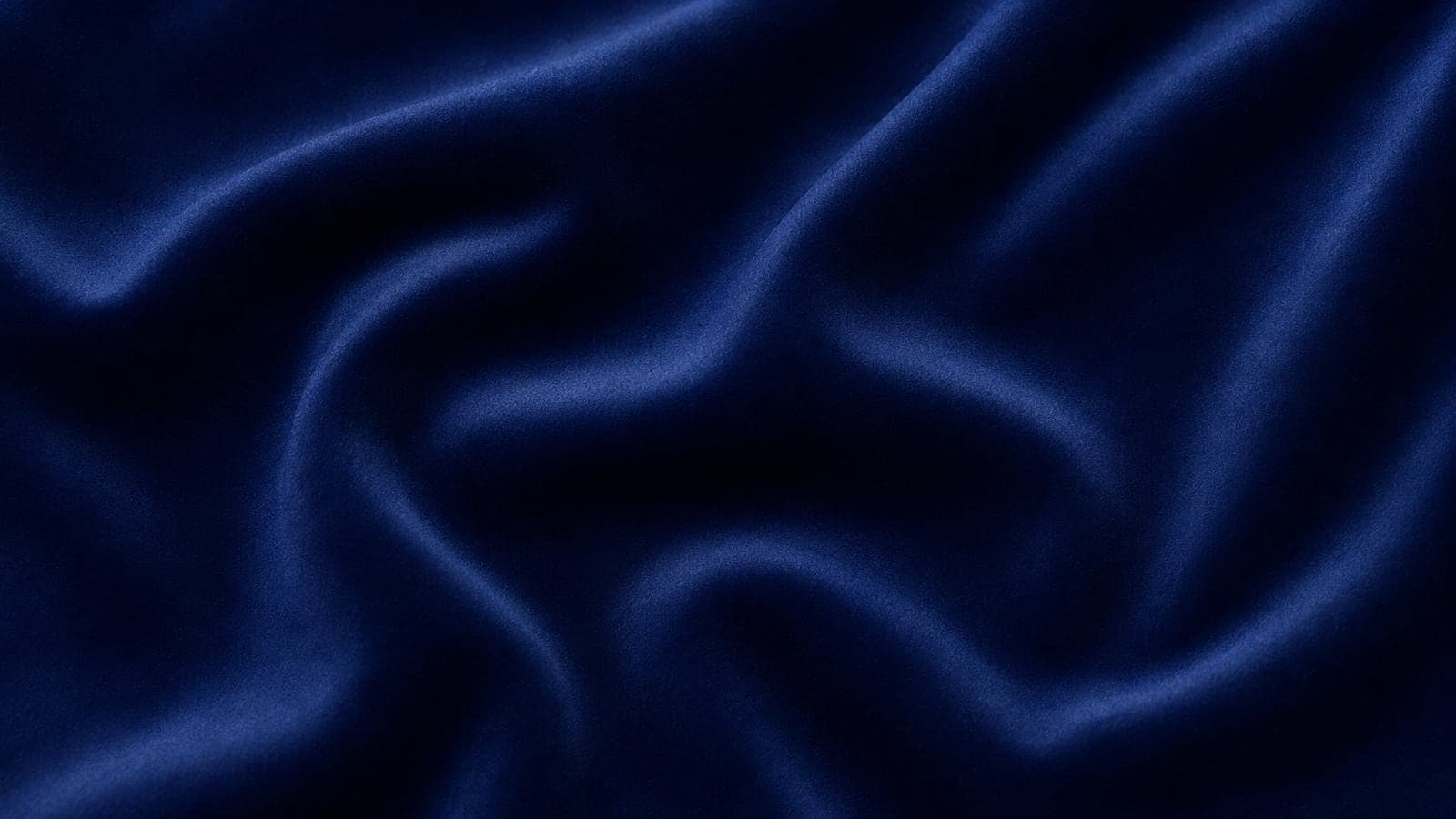 Veludo liso azul-marinho drapeado, com brilho concentrado nas cristas das dobras