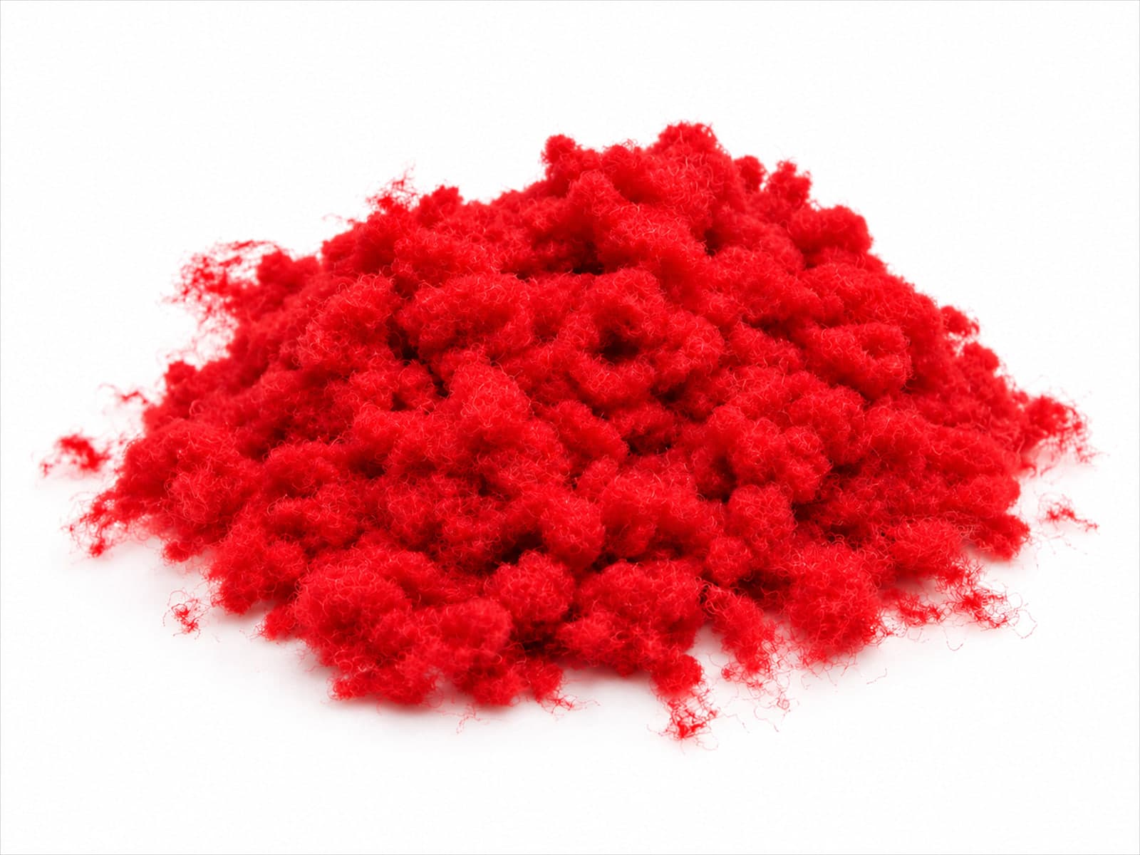 Monte de floco de nylon vermelho, em tufos macios e fofos, sobre fundo branco