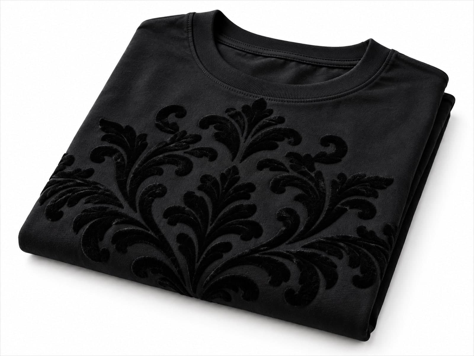 Camiseta preta dobrada com estampa flocada em relevo, em desenho de damasco, sobre fundo branco