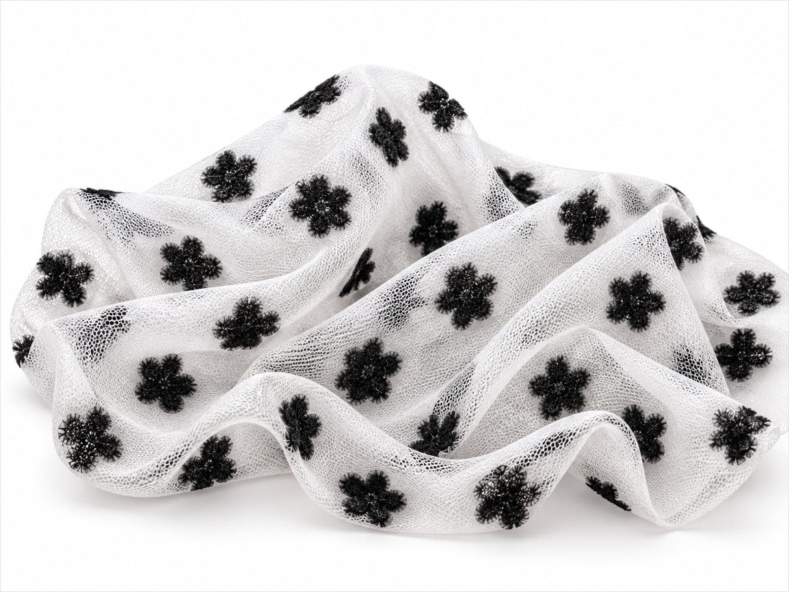 Corte de tule branco com flores aveludadas pretas em relevo, sobre fundo branco